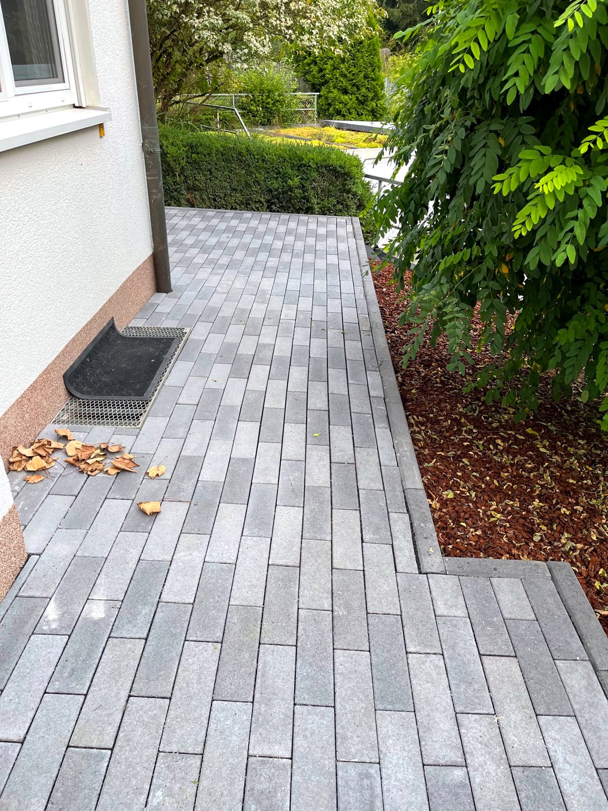 Fertig gepflasterter Hauszugang mit Blockstufen und sauberen Kanten