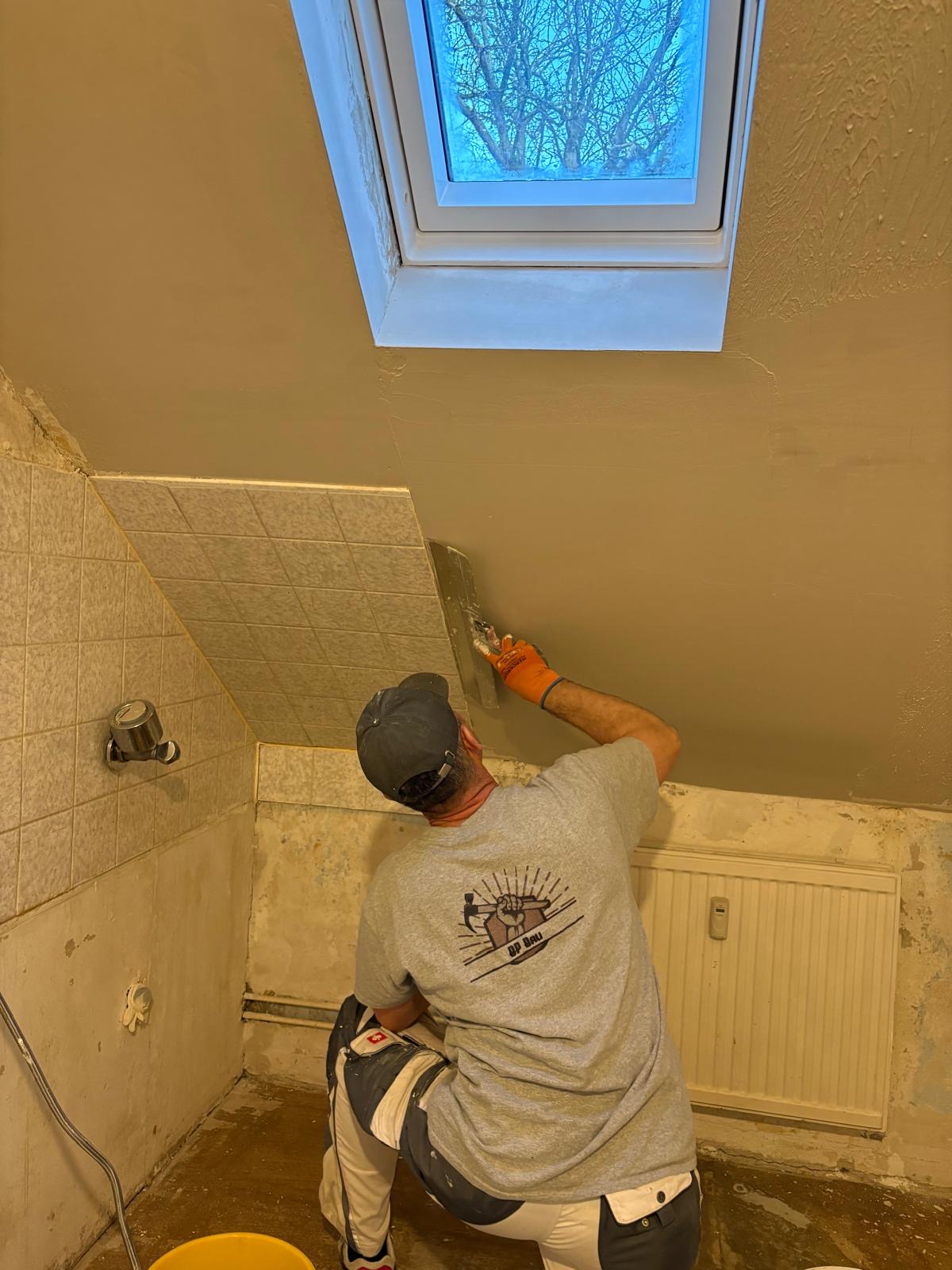 Handwerker von BP Bau beim Verspachteln einer Dachschräge